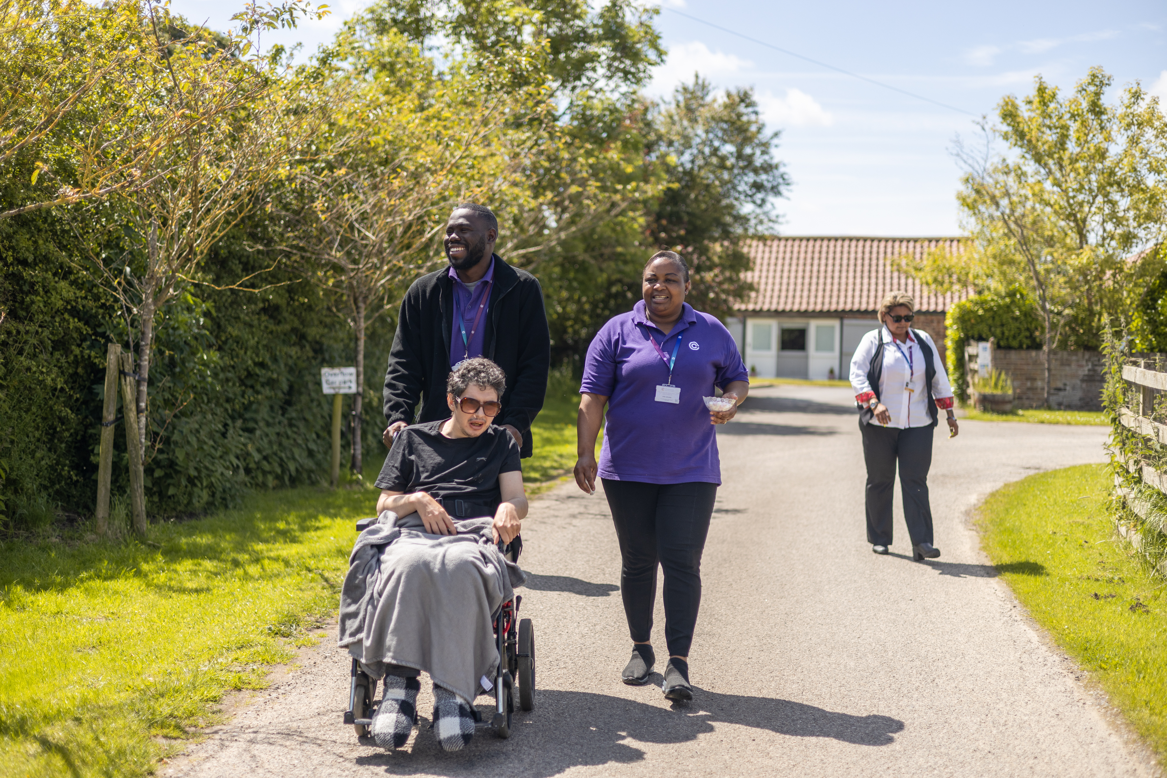 Careers taking a wheelchair user on a walk